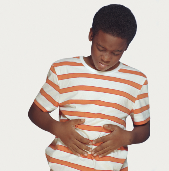 Boy (9-11) holding stomach, grimacing